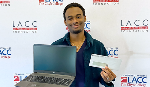 Student holding a laptop and check