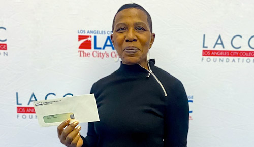 Older female student holding a check